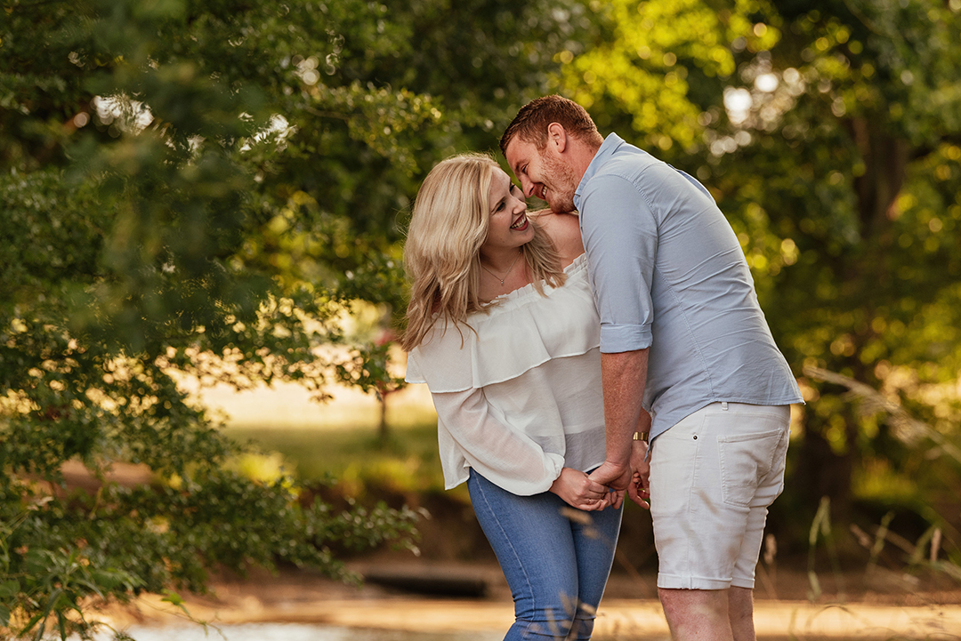 Couple hold hands laughing in Hylands Park Engagement Session