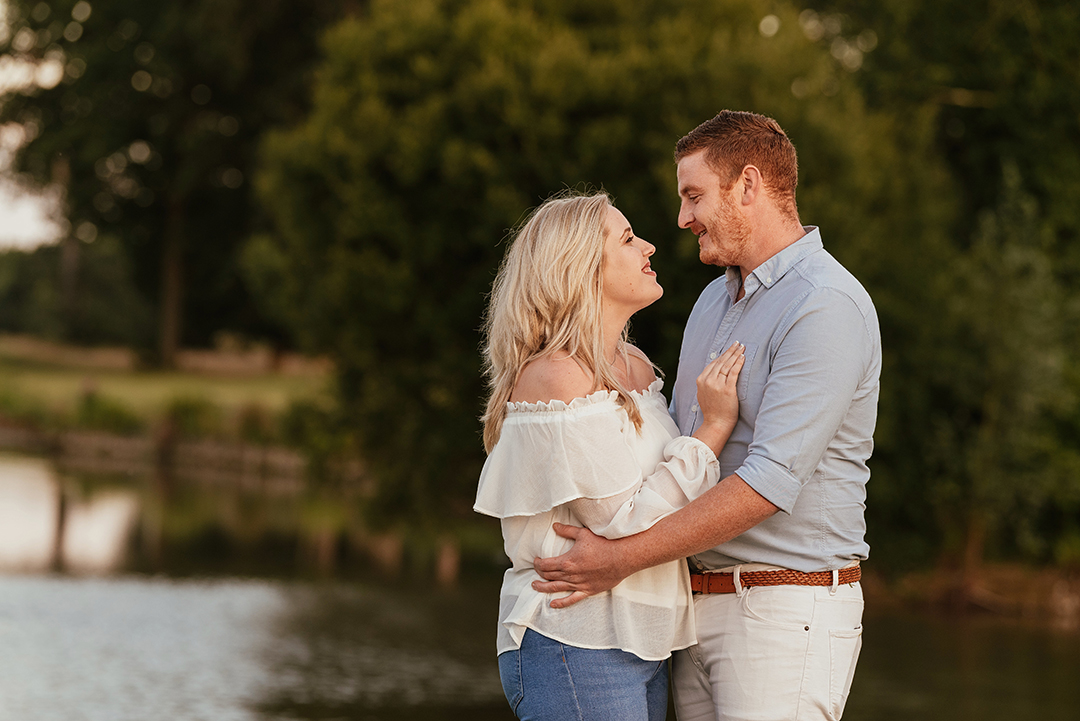 Couple embrace, lake in background Hylands park engagement session