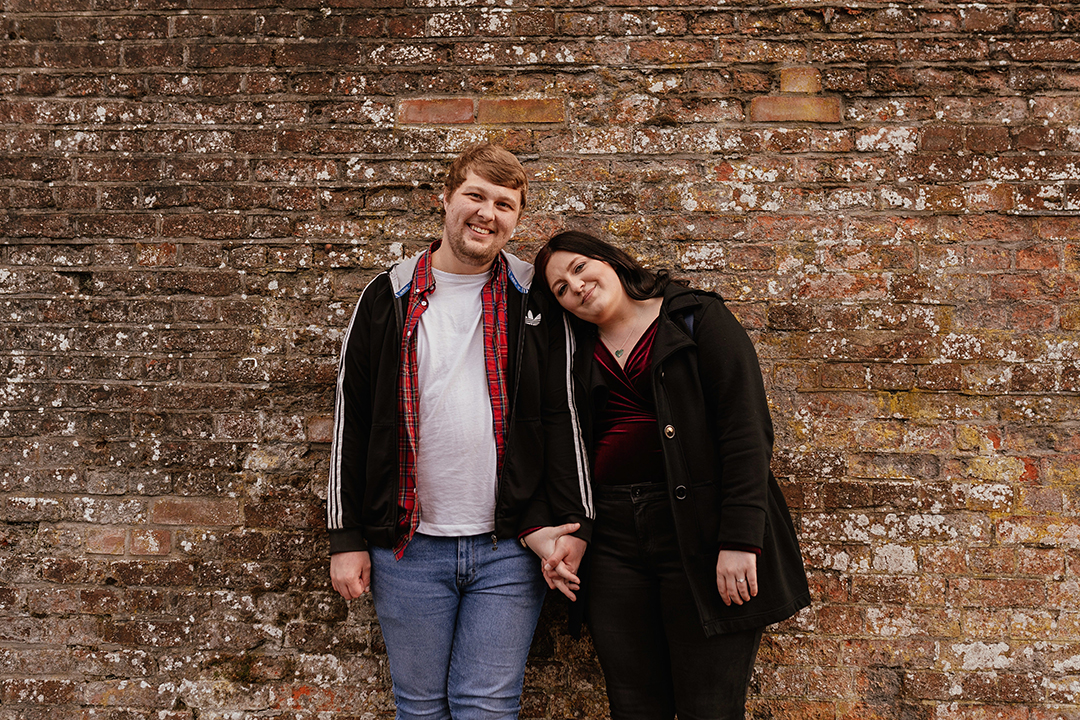 Couple stand by brick wall Castle Park Couples Session