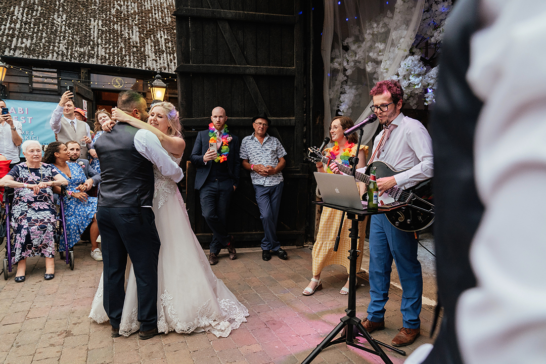 Stock Street Farm Barn Wedding Photography First Dance with Muscian and Guests in background