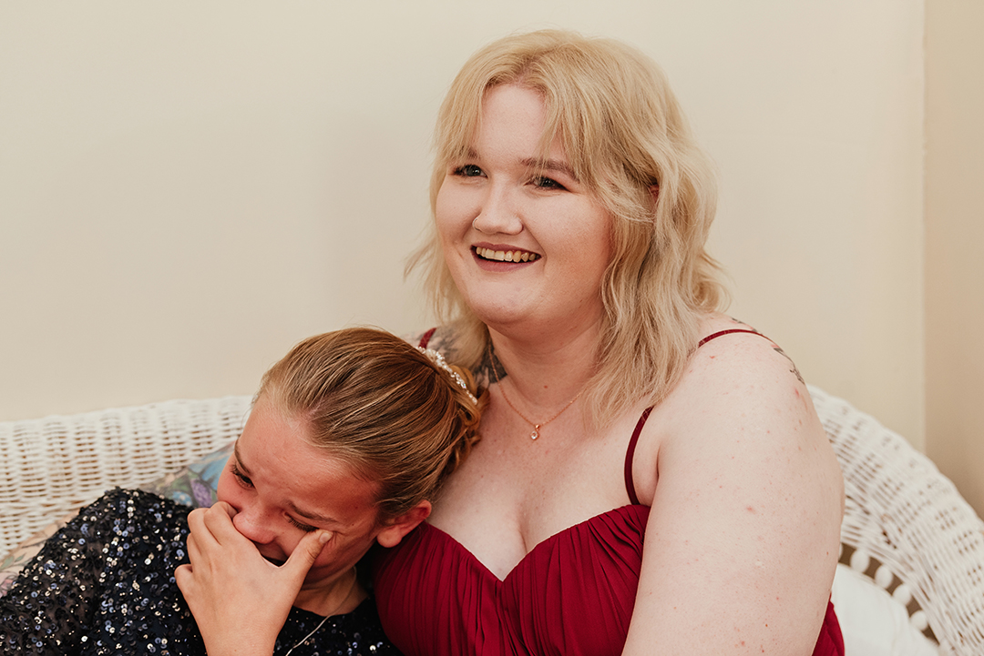 Bridesmaids both laugh and cry embracing Minstrel Court Wedding Photography