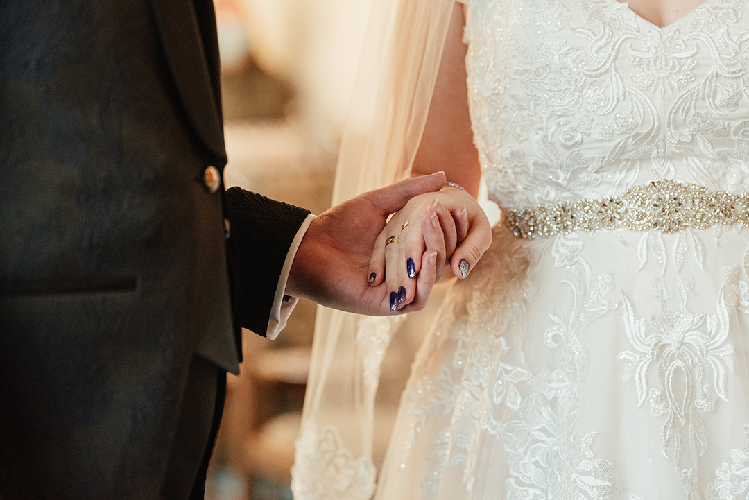 Close up of couple holding hands in Bishops Stortford Register Office wedding ceremony