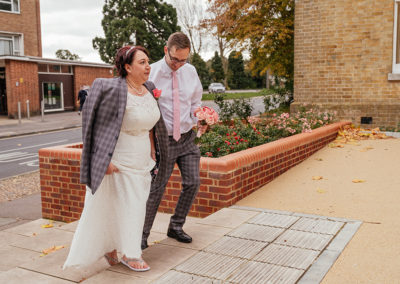 Groom gives bride his jacket in October wedding and walks her to the front of the Moot House Harlow Wedding Photography