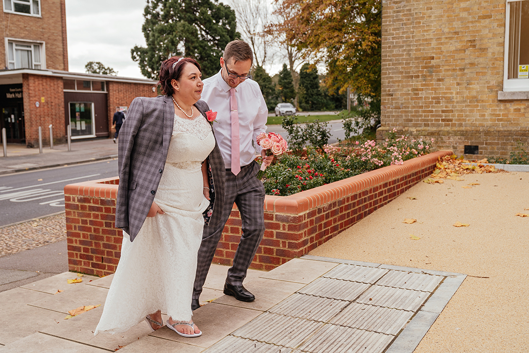 Groom gives bride his jacket in October wedding and walks her to the front of the Moot House Harlow Wedding Photography