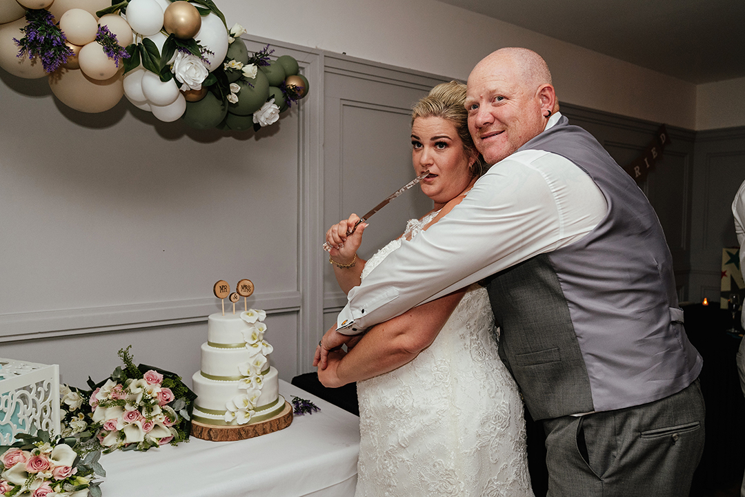 Bride Holds Knife to Groom Funny Cake Cutting The Rayleigh Club Wedding Photography