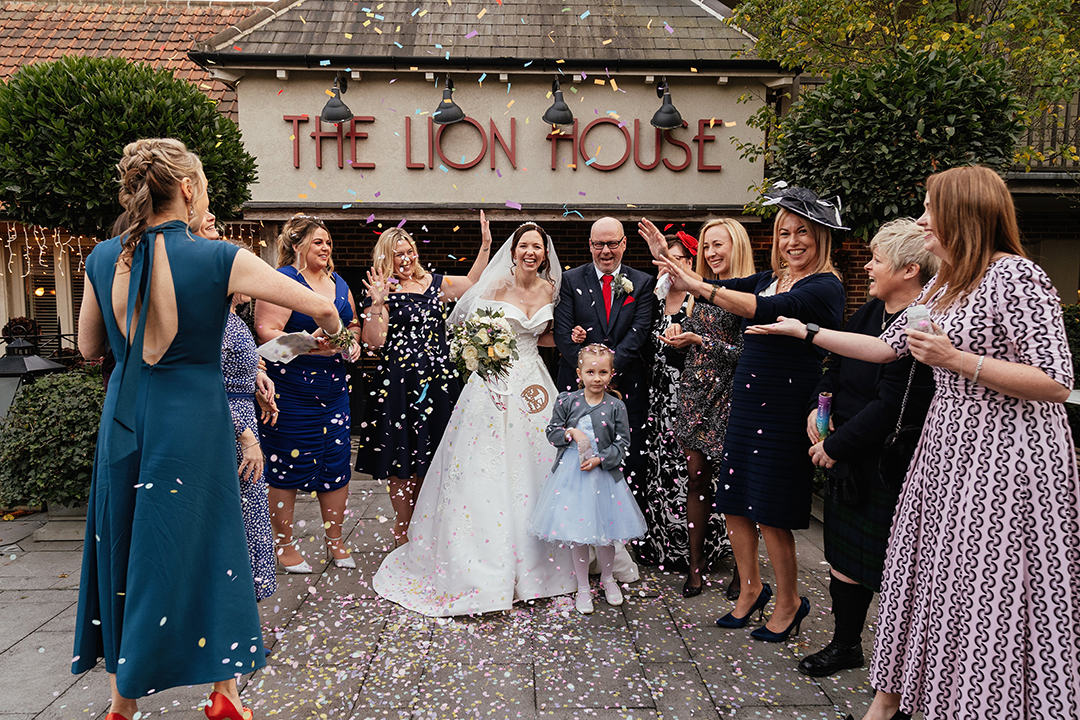 Couple outside front of The Lion House while guests throw confetti The Lion House Wedding Photography