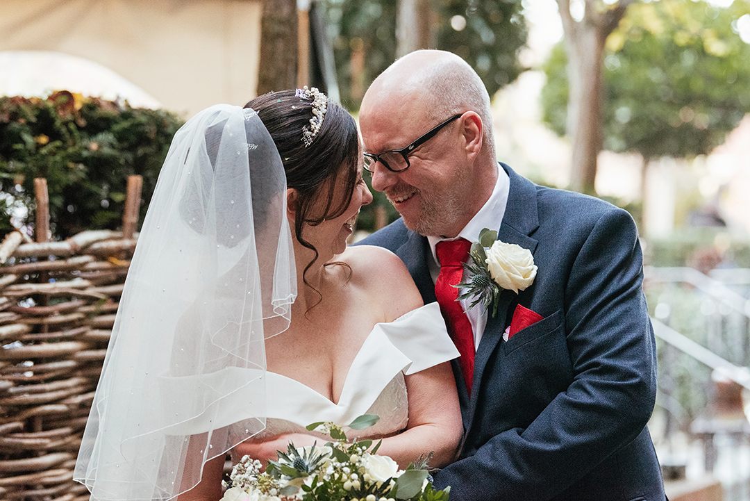 Groom embraces Bride from behind as they turn into each other with their foreheads together in beautiful intimate moment Natural Laughter Couples Photos The Lion House Wedding Photography