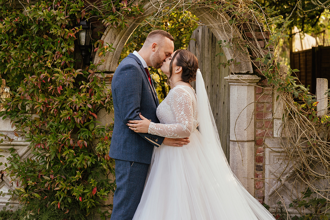 couple share kiss outside magic door Minstrel Court Wedding Photography