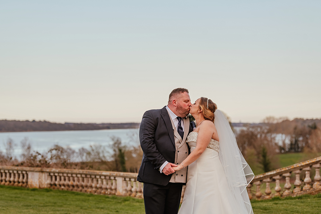 Couples Photos by Lake holding hands and kissing at Woolverstone Hall Wedding
