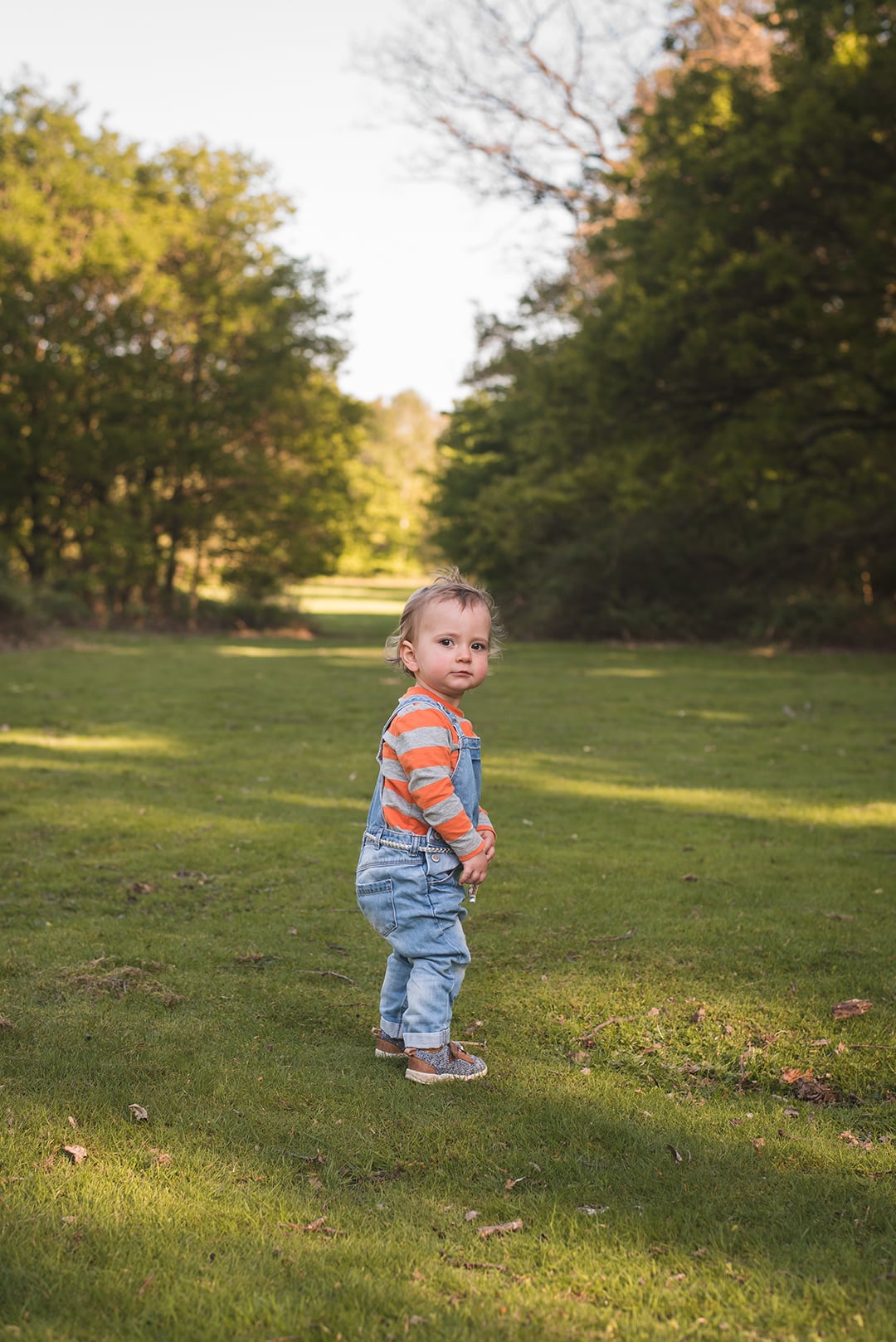 Cute baby girl stands in park in Epping