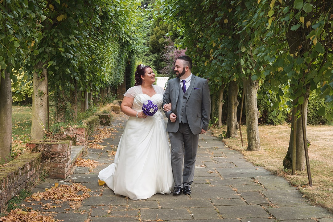 Couple walk towards camera in Parklands Quendon Hall gardens, Essex photography