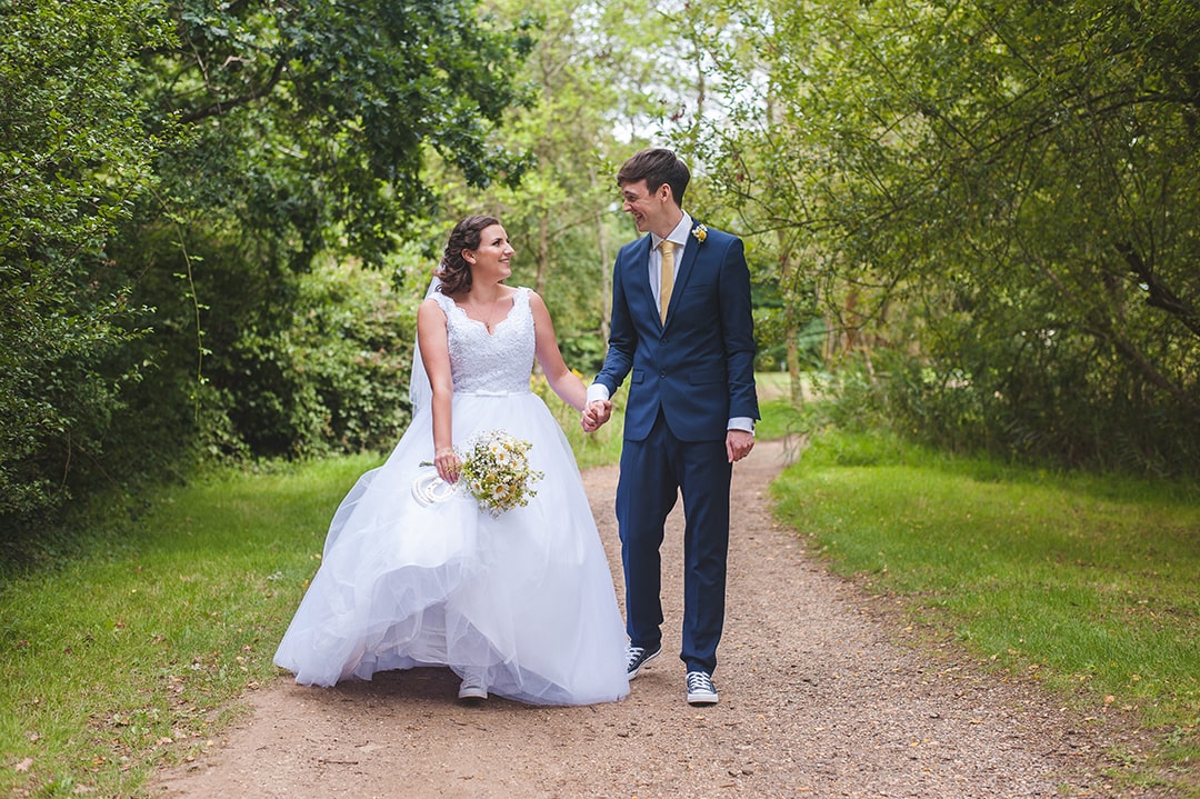 Bride and Groom share natural moment as they walk towards the camera