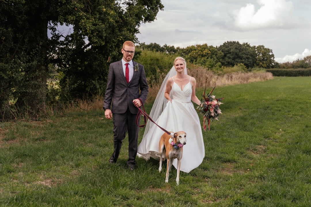 Dog friendly wedding venues in essex wedding couple with dog in field