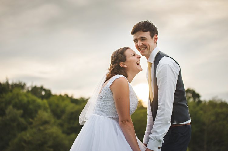 Essex Wedding photographer captures Couple at Sunset Holding Hands and Laughing