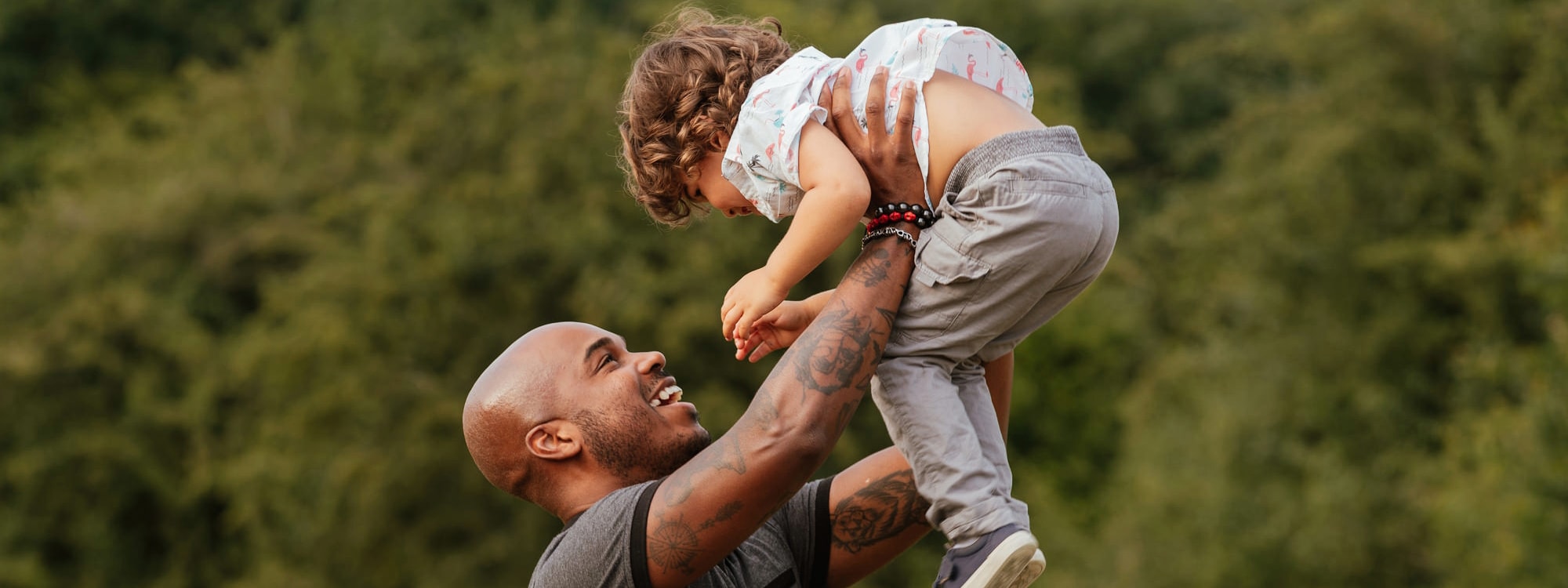 Dad holds young son in the air in Cute Family Photography Moment