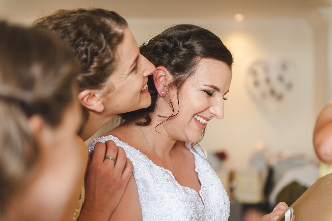 Bridesmaids laugh together in natural moment