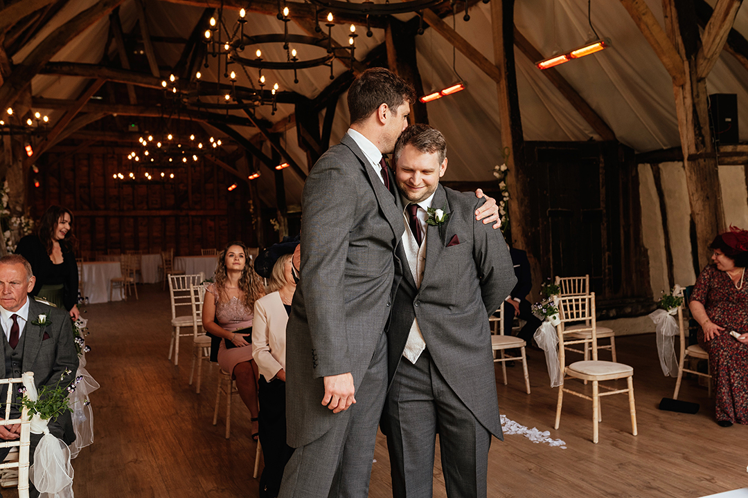 Groom and Best Man Embrace before wedding ceremony begins at Colville Hall