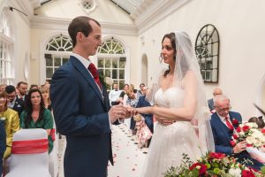 Essex wedding photographer Couple exchange rings at Hunton Park wedding Ceremony