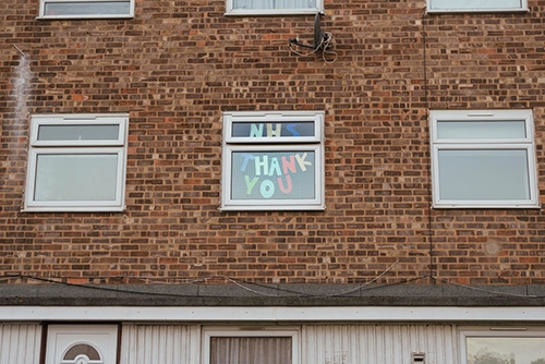 Cut out letters spelling NHS Thank You in someones window