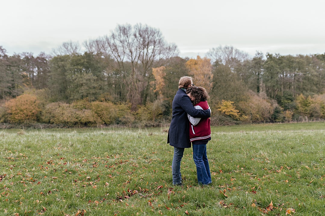 Couple embrace in natural engagement photo shoot