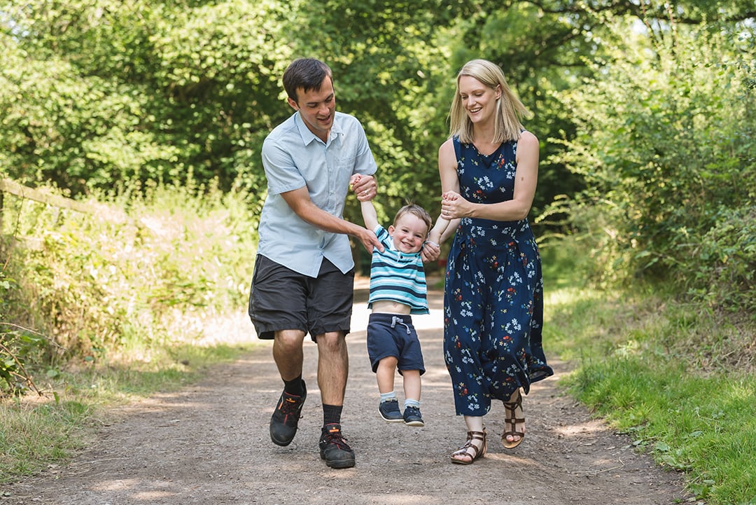 Mother and Father skip with son in natural Essex family session