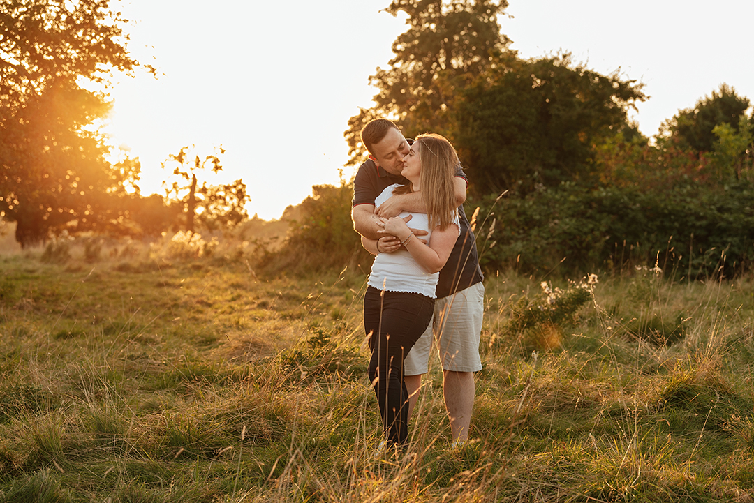 He hugs her from behind making her laugh with sunset in the background Sunset Pre Wedding Shoot at Pishiobury Park