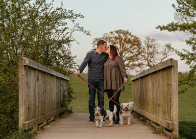 Dogs tangle leads in front of couple as they kiss