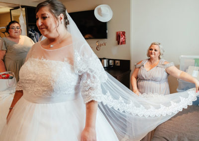 Brides veil held by bridesmaid