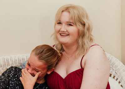 Bridesmaids laugh and cry together as they embrace
