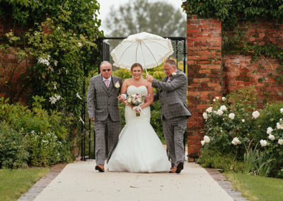 Bride walks down the aisle at Gaynes Park with dad and stepdad