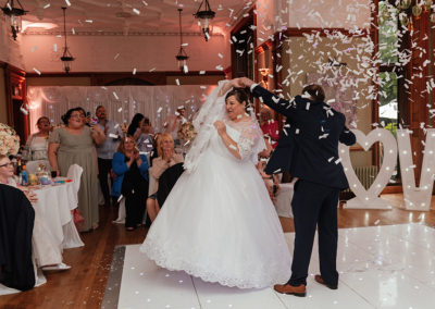 Confetti canons during first dance as groom spins the bride at Hertfordshire Golf Club