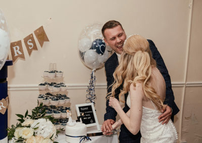 Couple cutting cake and laughing together