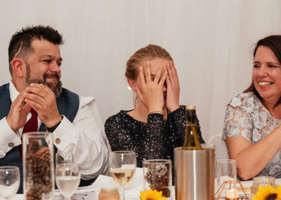 Bridesmaid covers face during speeches