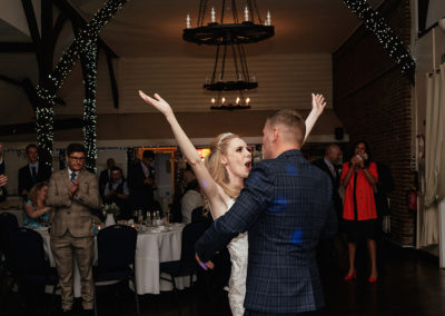 Bride waves hands in the air during dance