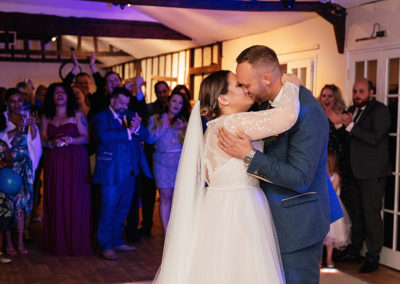 Couple embrace and kiss romantically during their first dance