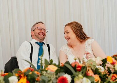 Bride and groom laugh during speeches