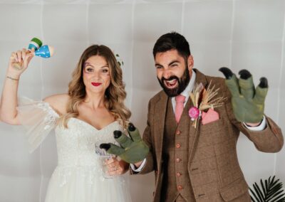Bride and groom pose with props in photobooth