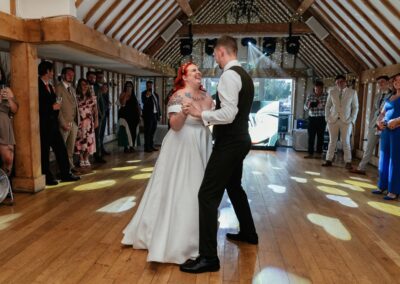 Bride and groom share first dance on barn dance floor