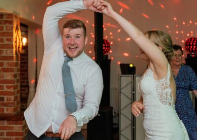 Bride twirls groom on the dancefloor in funny dance photo