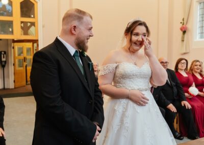 Bride wipes tear during wedding ceremony