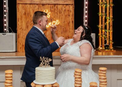 Couple feed wedding donuts to each other