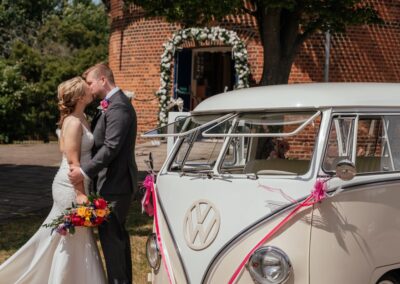 Couple kiss in front of windmill and campervan