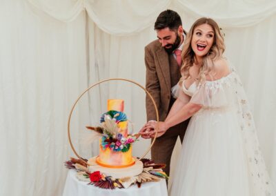 Couple laugh and cut wedding cake