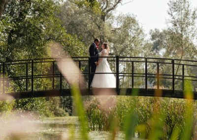 Couple stand on bride above lake