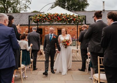 Couple walk back down aisle outdoor ceremony