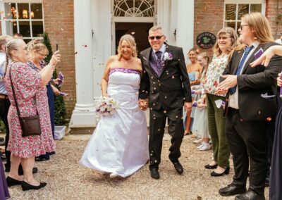 Couple walk through confetti at Mulberry House