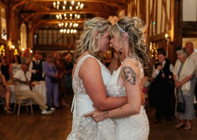 Two brides lay heads together romantic first dance photo