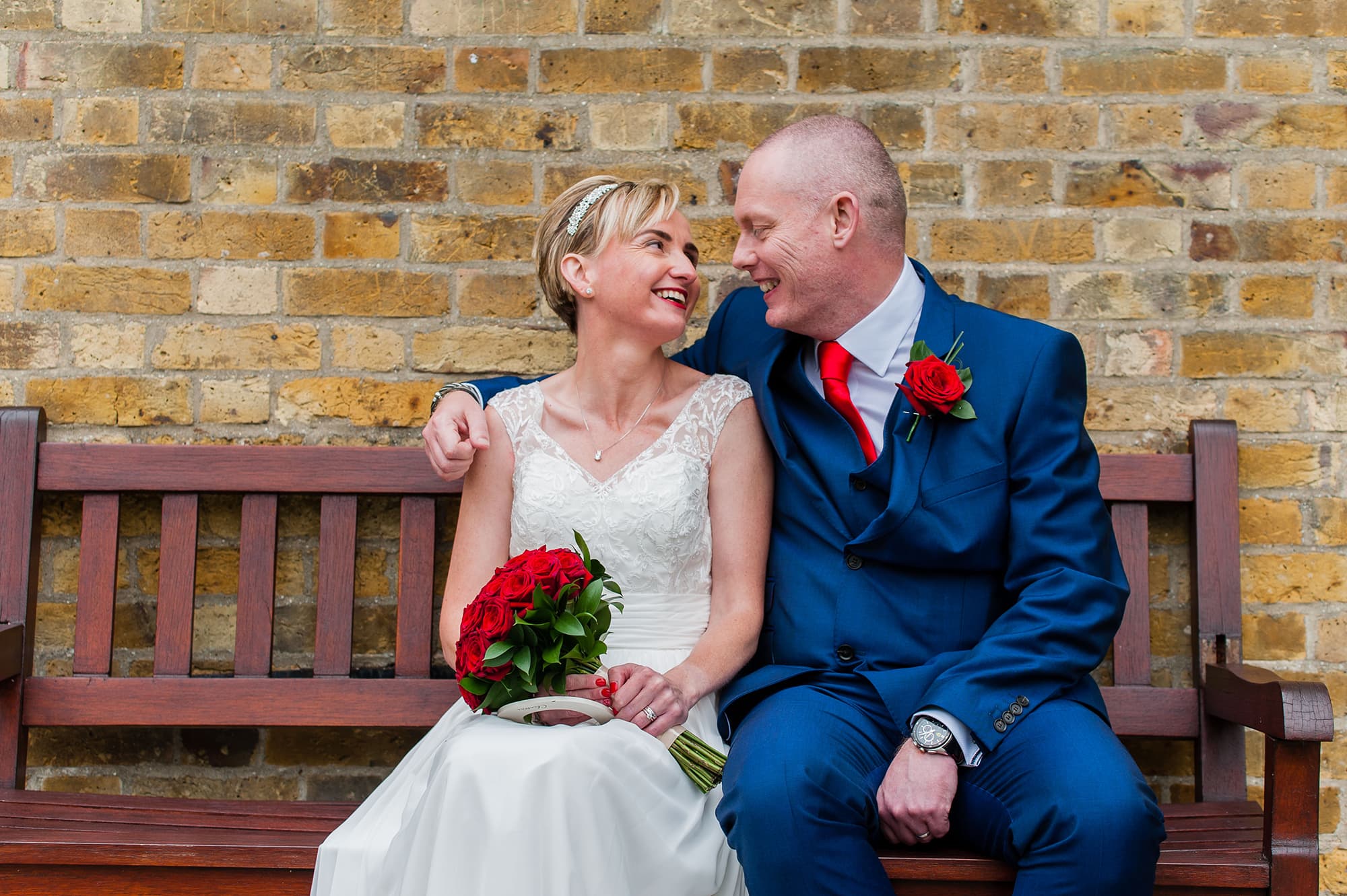 Couple look to each other smiling at Harlow Essex Wedding at the Moot House